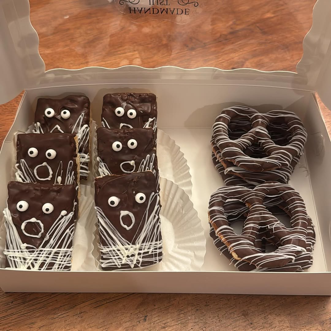 Halloween monster-themed box of six chocolate Rice Krispie bars with screaming faces and two striped chocolate pretzels.