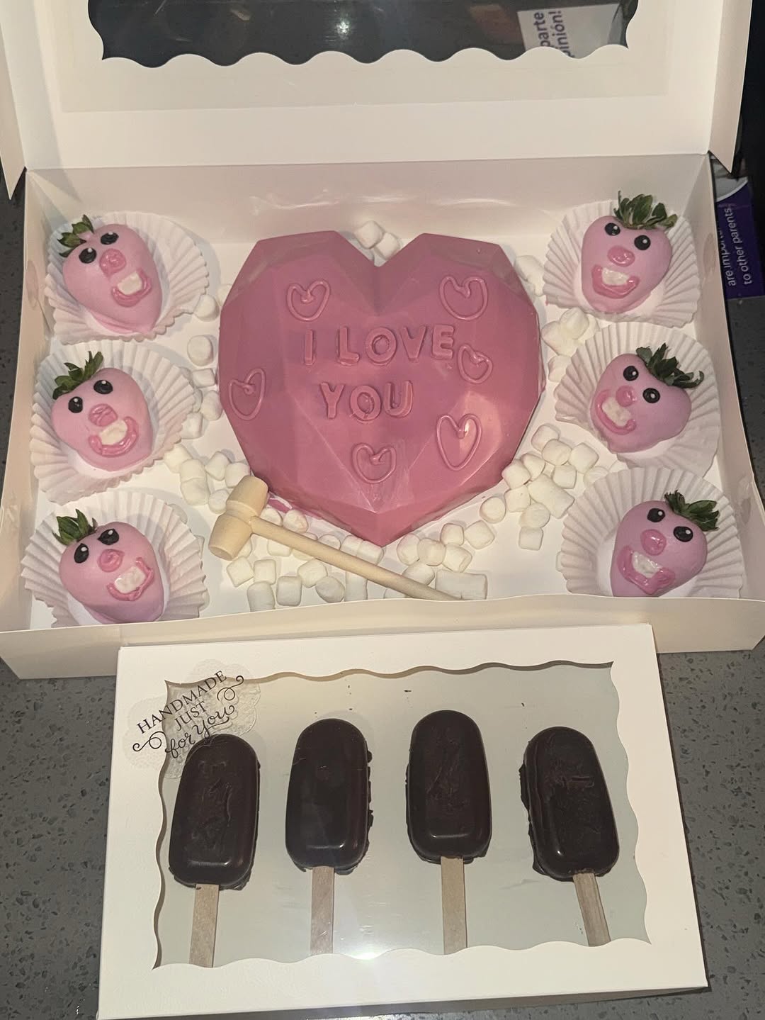 Valentine's Day gift set with a pink I LOVE YOU breakable heart, detailed pig-face strawberries, and a separate box of five dark chocolate cakesicles.